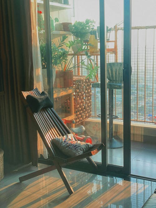 A chair sitting in front of a window with plants