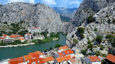 克罗地亚奥米斯的风景令人惊叹，河流蜿蜒穿过崎岖的山脉和红顶房屋