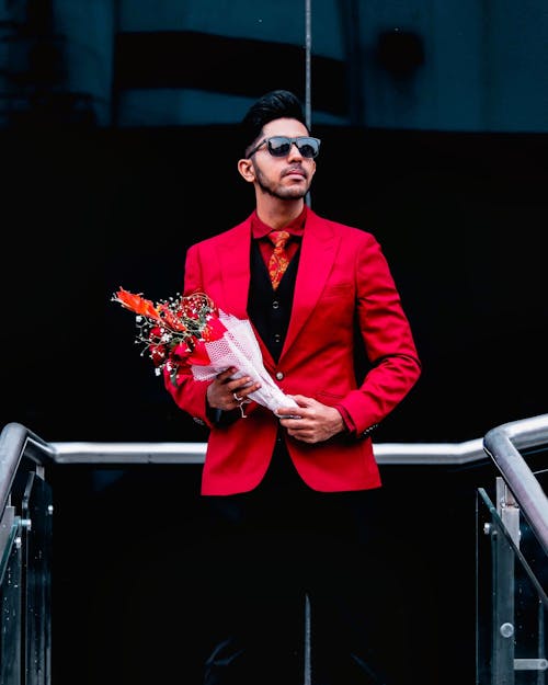 Photo of Man in Red Blazer Holding Bouquet of Flowers