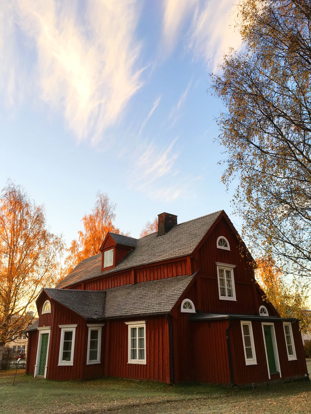 Older New Jersey colonial-style home with steep gable roof and mature autumn trees