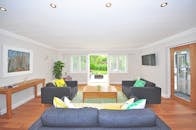 Brown Wooden Coffee Table Near Black Sofa Near the Window