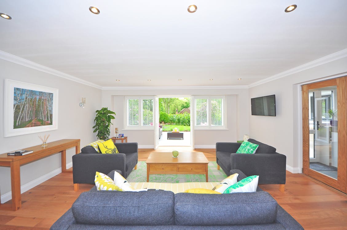 Free Brown Wooden Coffee Table Near Black Sofa Near the Window Stock Photo