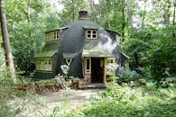 舒适的圆形房屋坐落在郁郁葱葱的森林中，非常适合自然爱好者