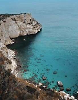 Stunning aerial view of Sardinian cliffs and turquoise waters. Perfect for travel and nature photography. by Symeon Ekizoglou