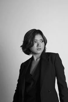 这幅优雅的黑白肖像展现了一位身着职业装的现代女性，尽显时尚风范