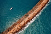 Ship on Body of Water Near Rock Formation