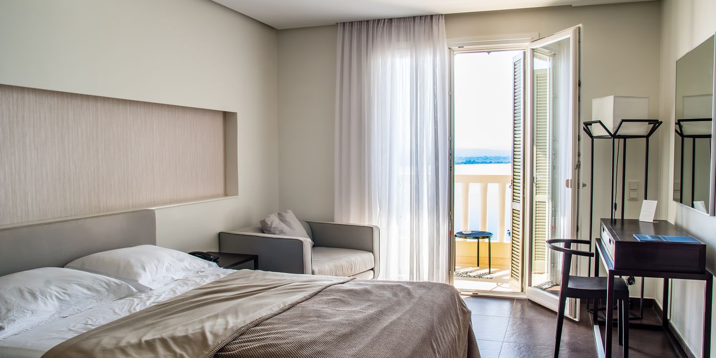 A bright hotel room with a balcony in daytime, the kind of room booked as a day-use stay in 2026