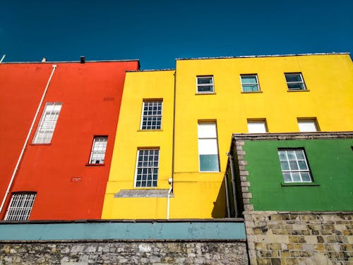 無料 黄色とオレンジ色のコンクリート住宅のローアングル写真 写真素材