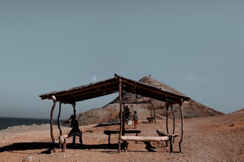 Free Person Standing Under Hut Stock Photo