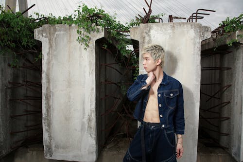 Free A man in denim jacket standing next to some concrete Stock Photo