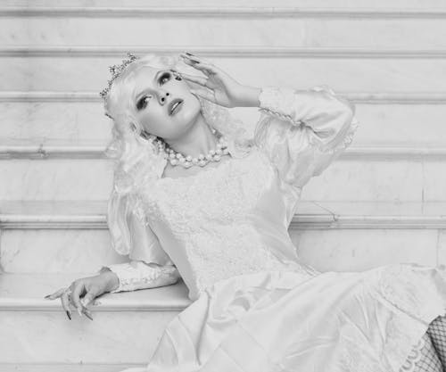 Free A woman in a white dress sitting on some stairs Stock Photo