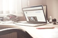 一个干净明亮的工作空间里，一台笔记本电脑放在木桌上，凸显出典型的技术环境