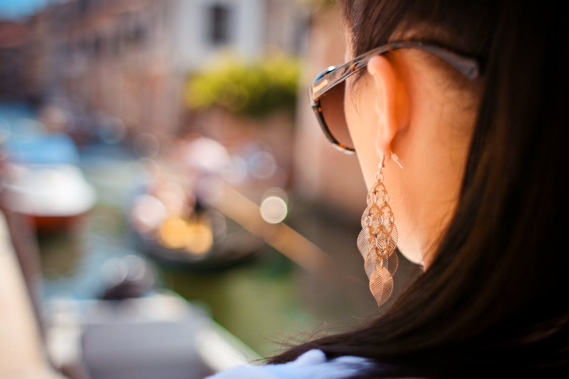 бесплатная женщина носит серьги подвески и солнцезащитные очки Стоковое фото