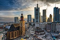 法兰克福的城市景观令人惊叹，日落时分，摩天大楼与历史悠久的教堂交相辉映