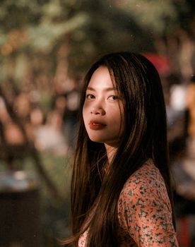 在柔和的自然光下，一位亚洲女性优雅地伫立于越南的自然环境中