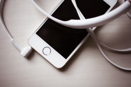 Bezpłatne Biały Zestaw Słuchawkowy Podłączony Do Gold Iphone 5s Zdjęcie z galerii