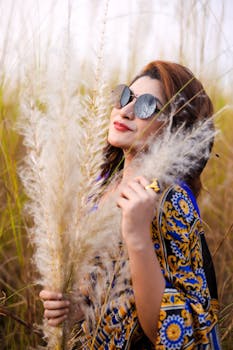 在阳光明媚的麦田里，时尚女人摆出姿势，展现现代时尚与优雅