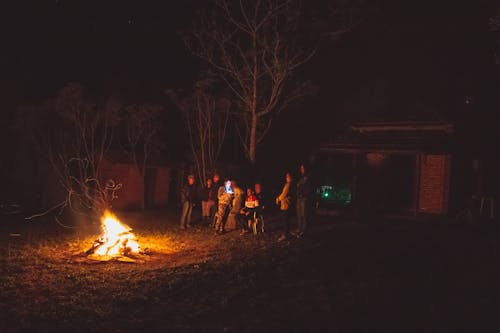 Ludzie Stojący W Pobliżu Ogniska W Nocy