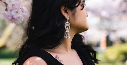 A woman wearing earrings and a black dress