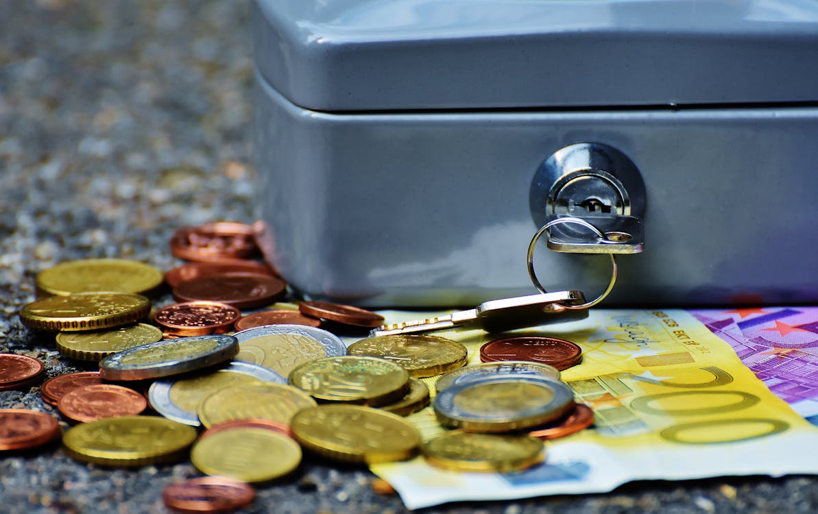 Billetes Y Monedas Junto A La Caja De Seguridad Gris