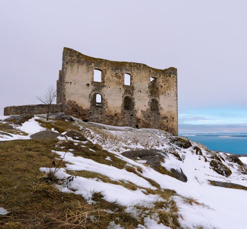 An old building on top of a snowy hill