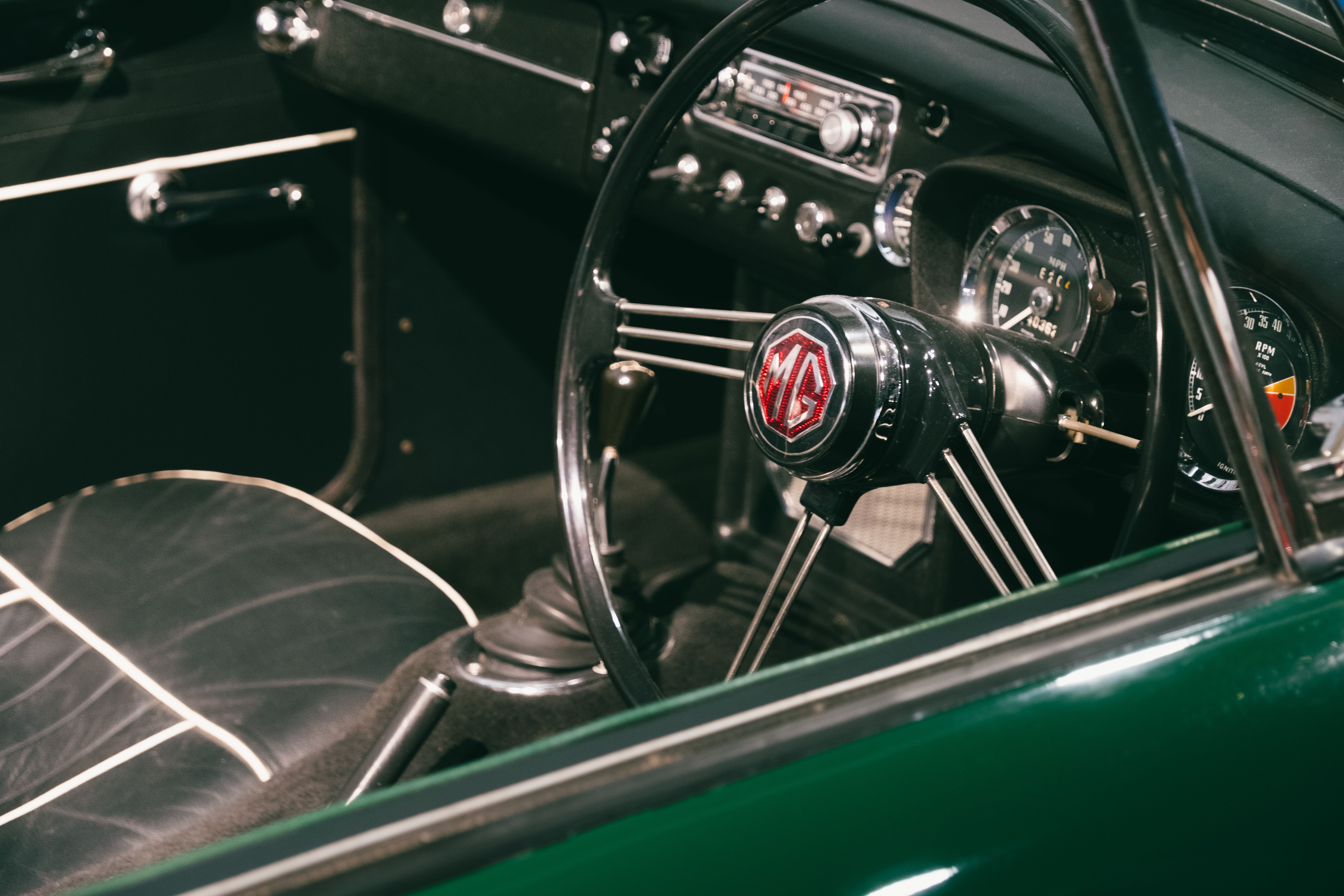 Explore the vintage charm of a classic MG cabriolet interior, highlighting its retro dashboard and steering wheel.