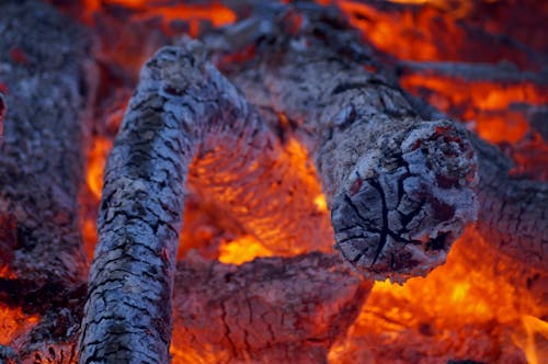 A close up of a fire with flames and logs