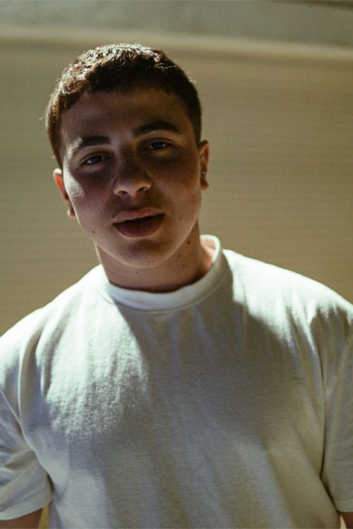 Free Casual portrait of a young adult in a white t-shirt with soft indoor lighting. Stock Photo