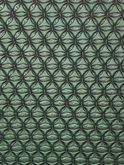 A green and black ceramic tile with a pattern