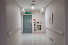 Quiet hospital corridor leading to emergency exit, features clean and minimal design.
