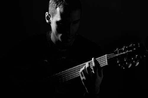 Grayscale Photo of Man Playing Guitar