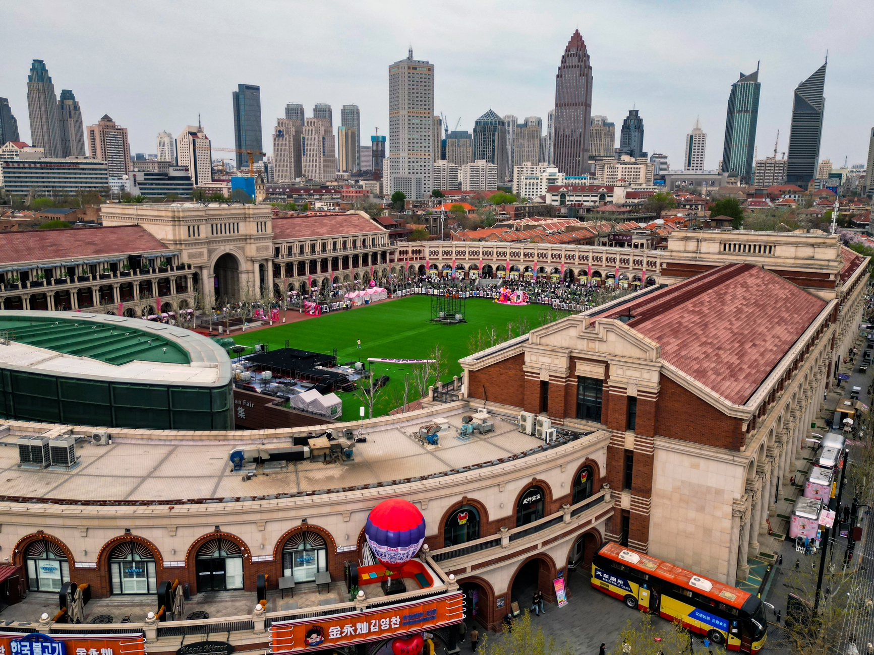 Drone shot of Tianjin cityscape featuring a vibrant stadium and iconic skyline.