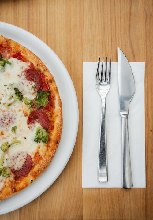 Free Cutlery Next to a Plate with Pizza Stock Photo