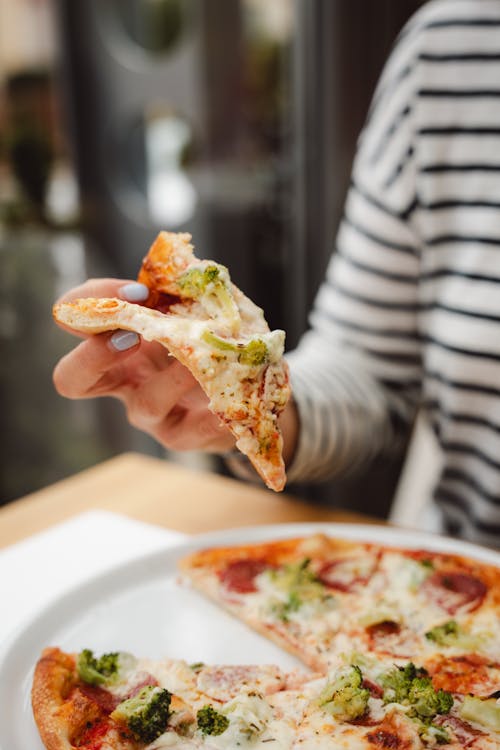 Eating Pizza with Salami and Broccoli