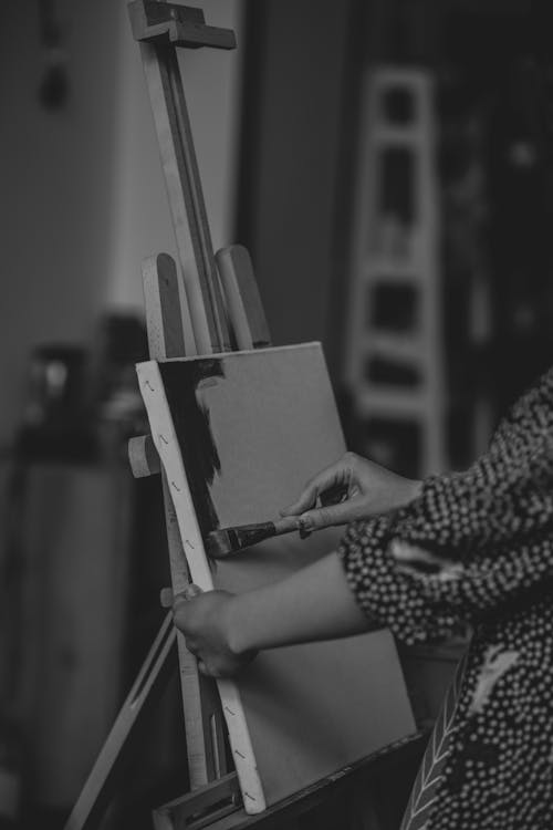 A woman is painting on an easel