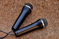 特写镜头展示了两个黑色手持麦克风，置于纹理背景上，非常适合音频主题