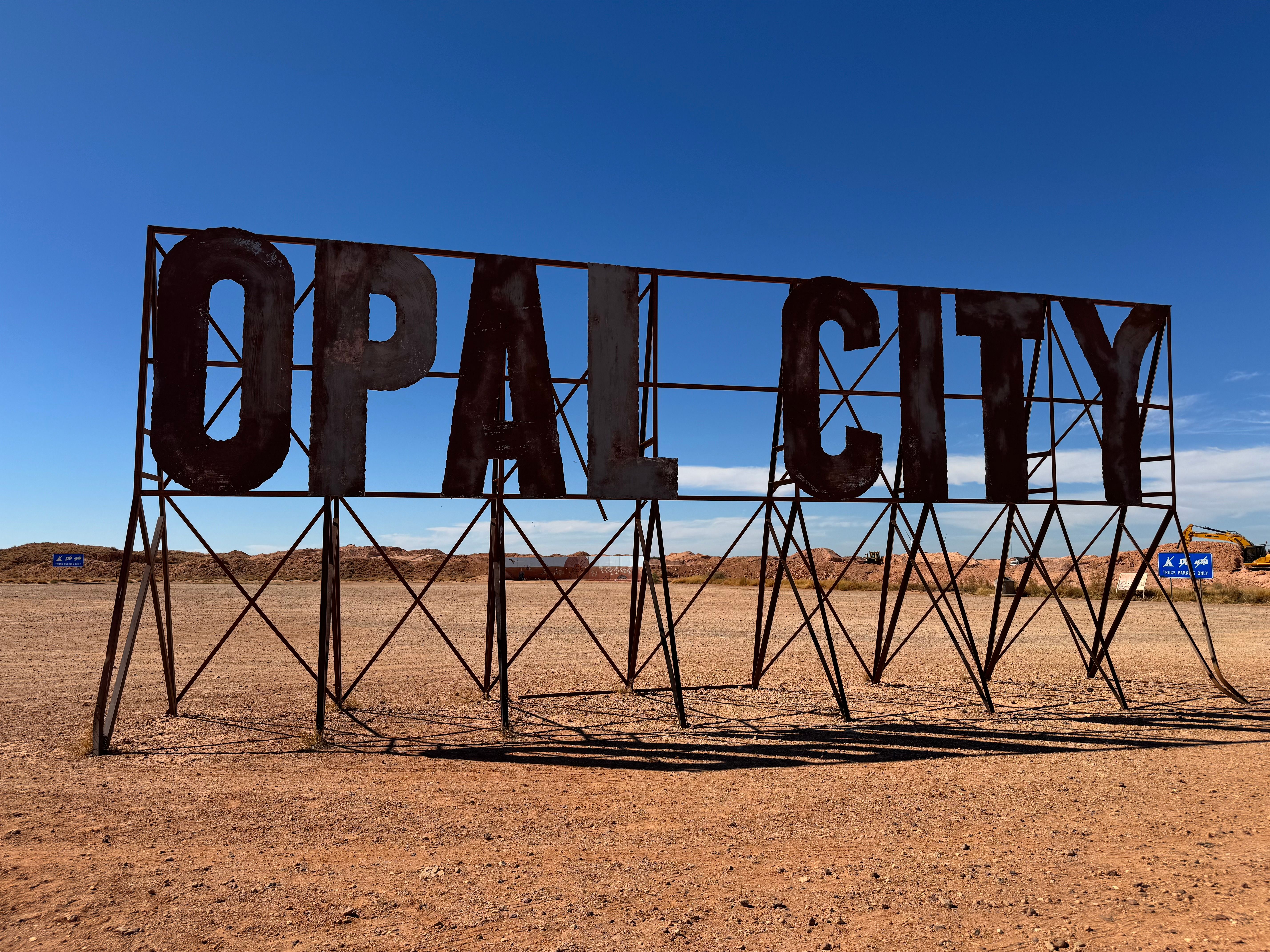 Rustic Opal City sign stands in the arid expanse of Central Australia, NT.