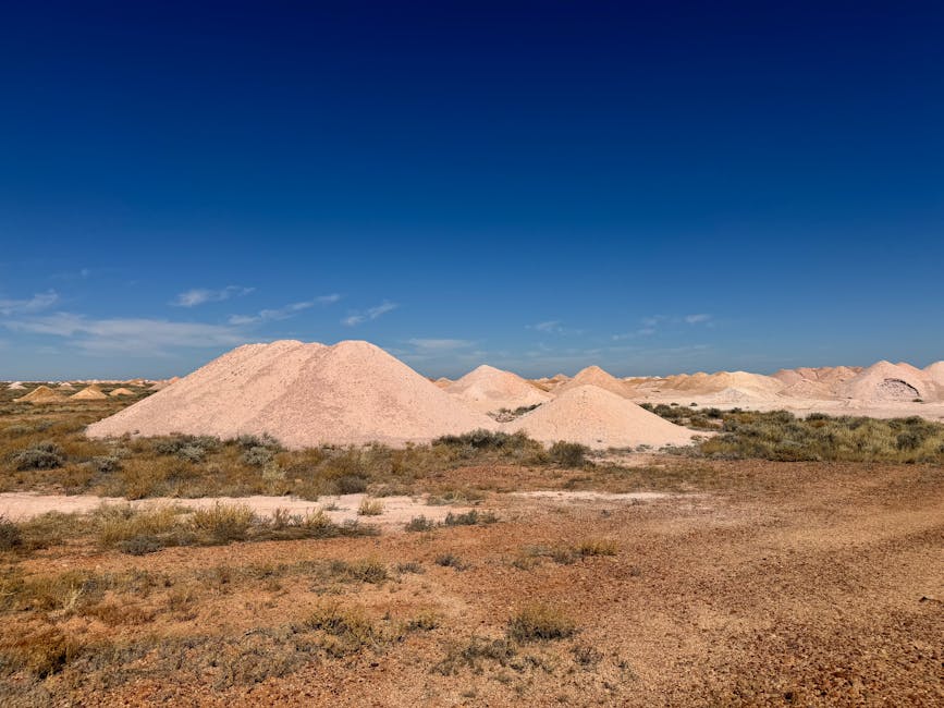 Scenic view of Australian desert showcasing mine dumps under clear blue sky.