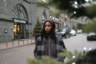 一位穿着冬装的时尚女性站在城市街道上，靠近一家奢侈品商店