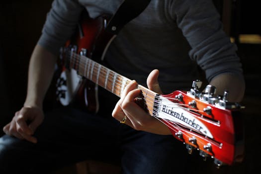 A focused view of a man playing a Rickenbacker guitar, highlighting the instrument's craftsmanship.