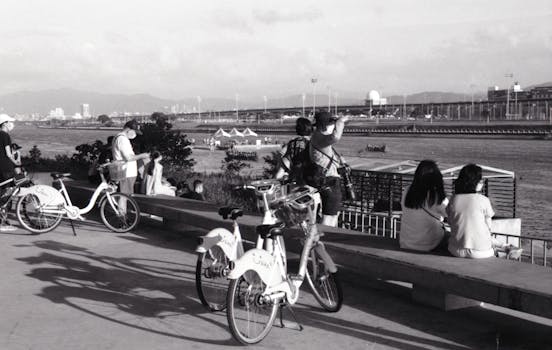 Enjoy the vibrant river scene along Taipei's bustling riverbank with bicycles and visitors.