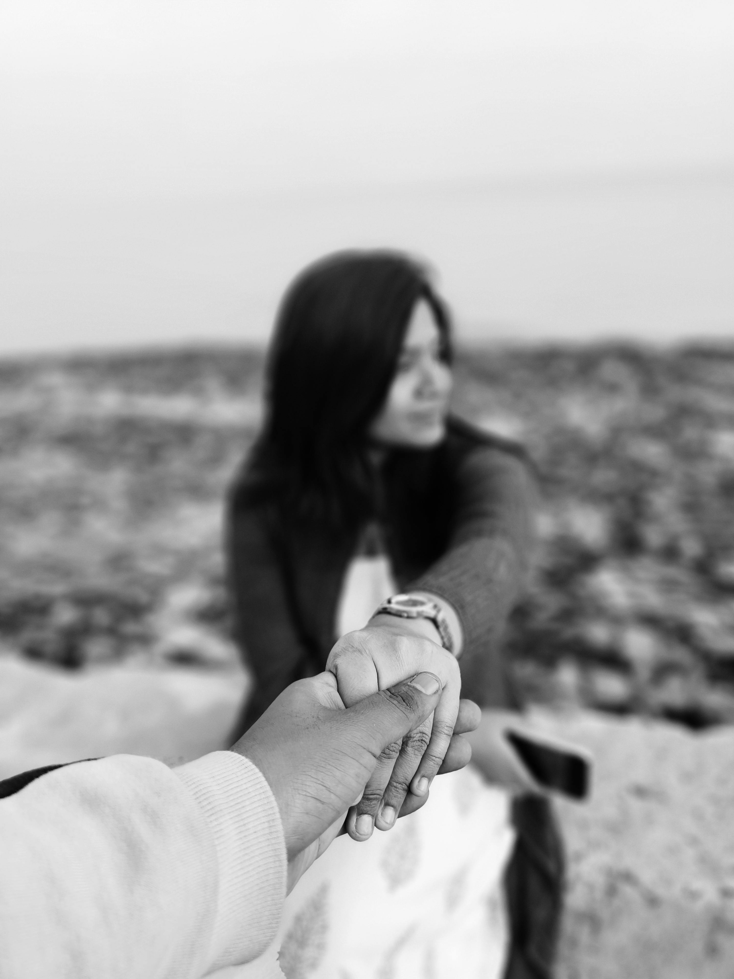 A symbolic black and white image capturing a couple's connection at the beach.