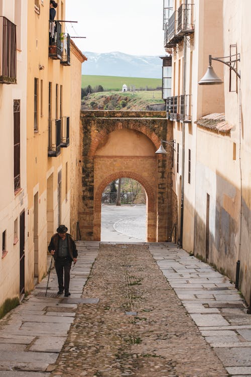 Elderly Man Walking on Cobblestone Street in Old Town in Segovia in Spain