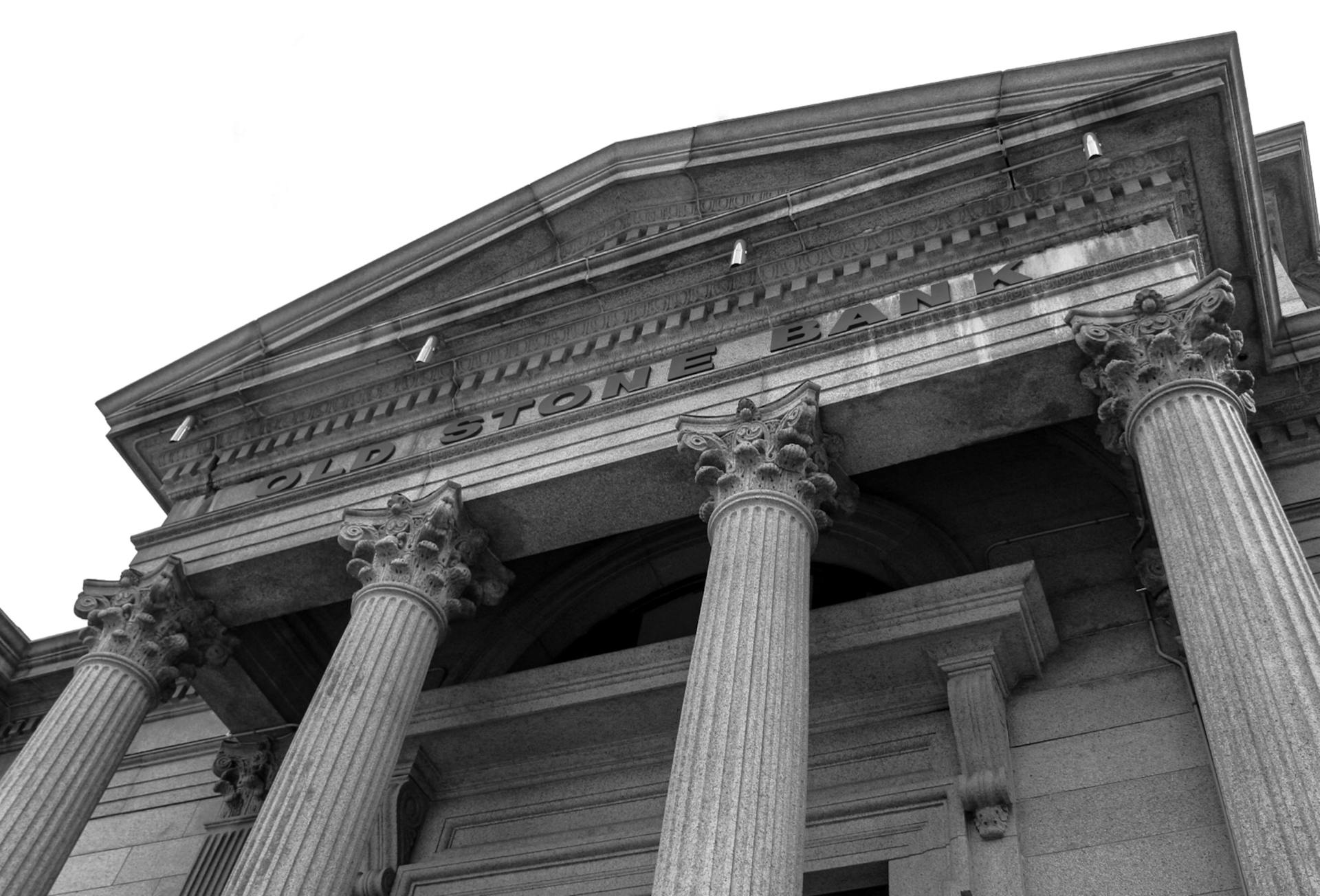 Black and white photo of the historic Old Stone Bank showcasing classical columns and architectural detail.