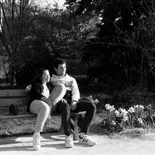 A couple sitting on a bench in a park