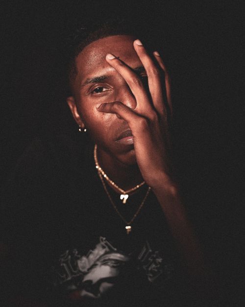 Free Close-up portrait of a stylish young man in Atlanta with a thoughtful pose and golden chains. Stock Photo