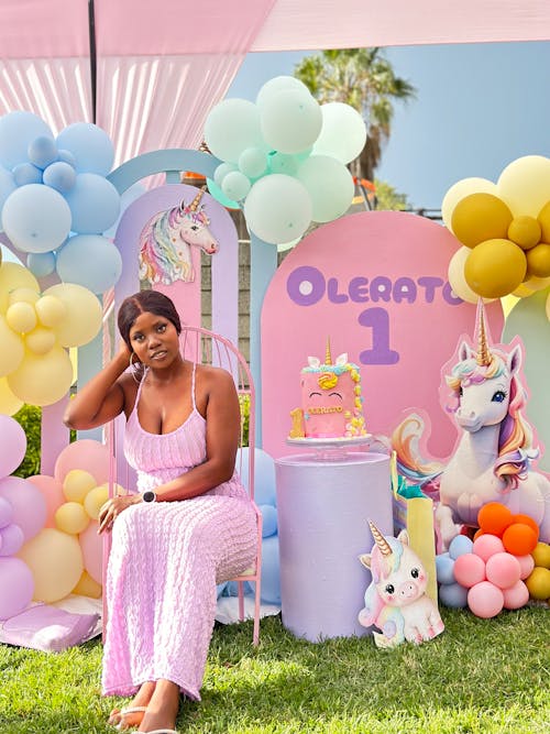 A woman sitting in front of a unicorn themed birthday party