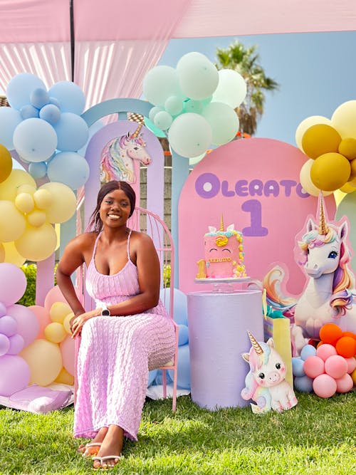 Free A woman sitting in front of a unicorn themed birthday party Stock Photo