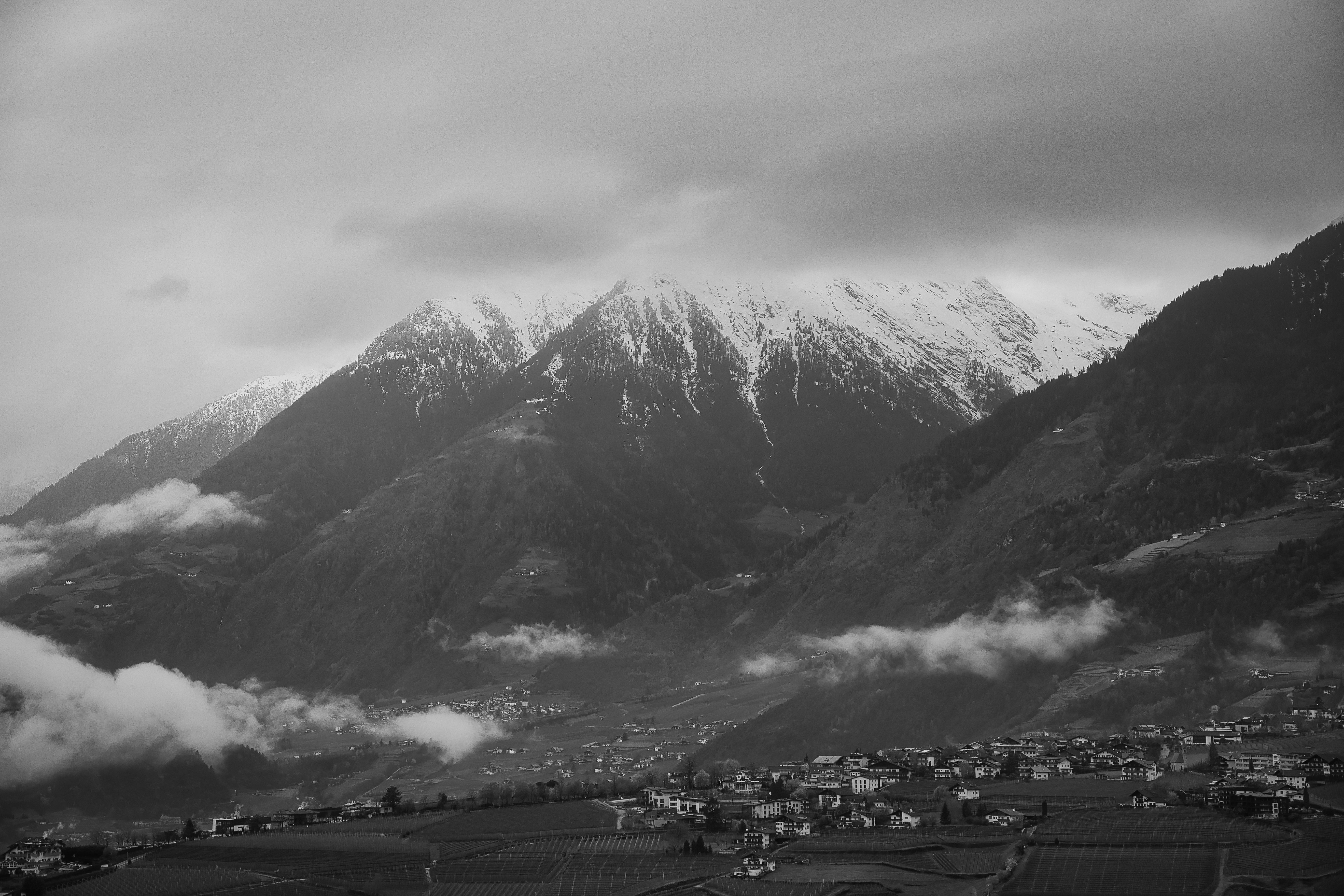 Scenic View of a Village in a Mountain Valley and Snowcapped Mountains ...