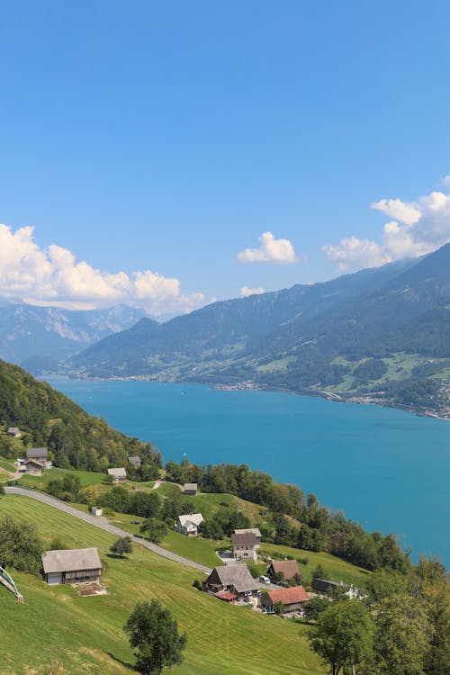 Free View of Hillside Houses by the Lake in Mountains  Stock Photo